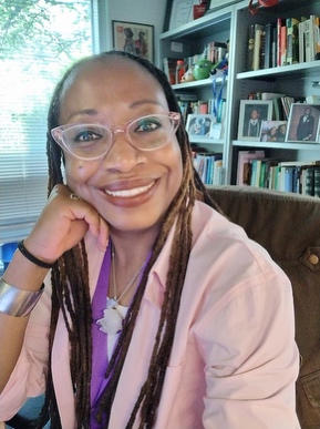 A person with glasses and pink shirt

AI-generated content may be incorrect.