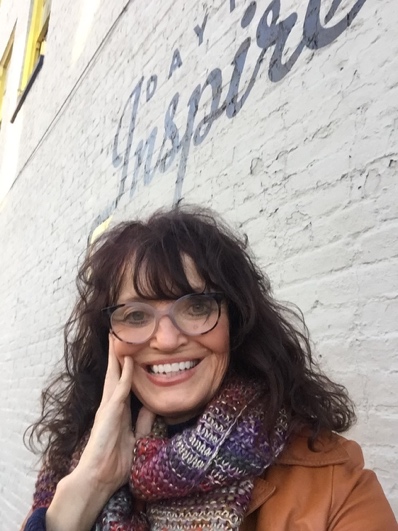 A person smiling with glasses and a scarf

AI-generated content may be incorrect.