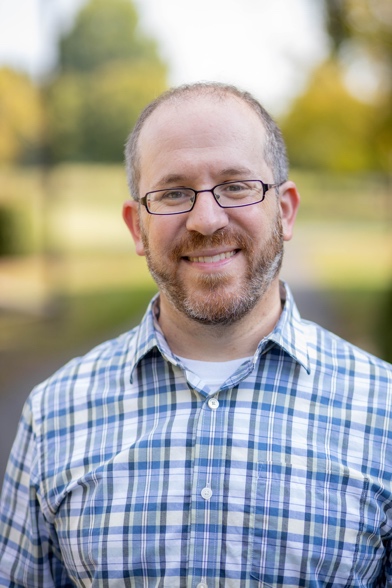 A person wearing glasses and a plaid shirt

AI-generated content may be incorrect.